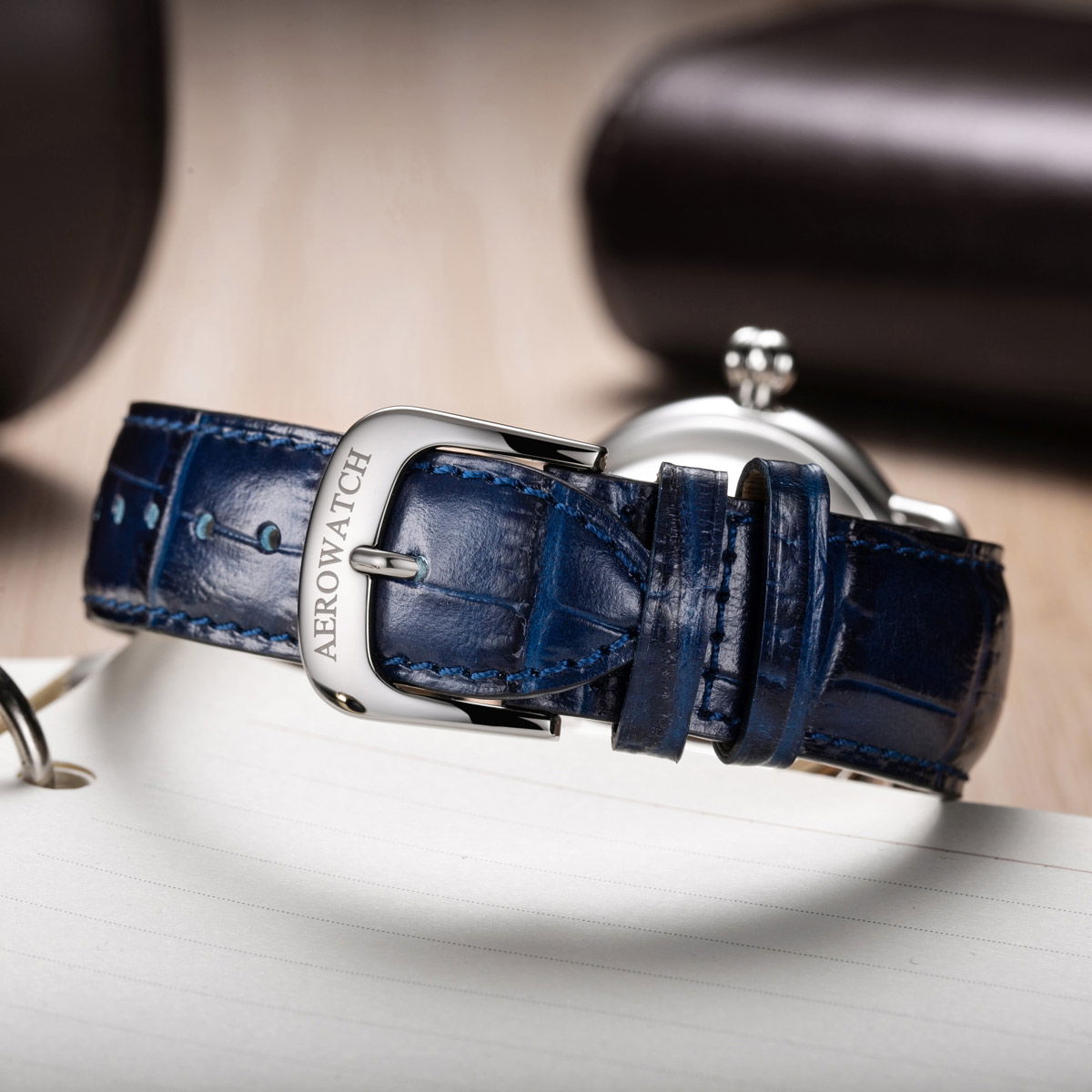 Stylish Aerowatch 1942 Automatic watch strap with a blue leather finish and silver buckle detail.