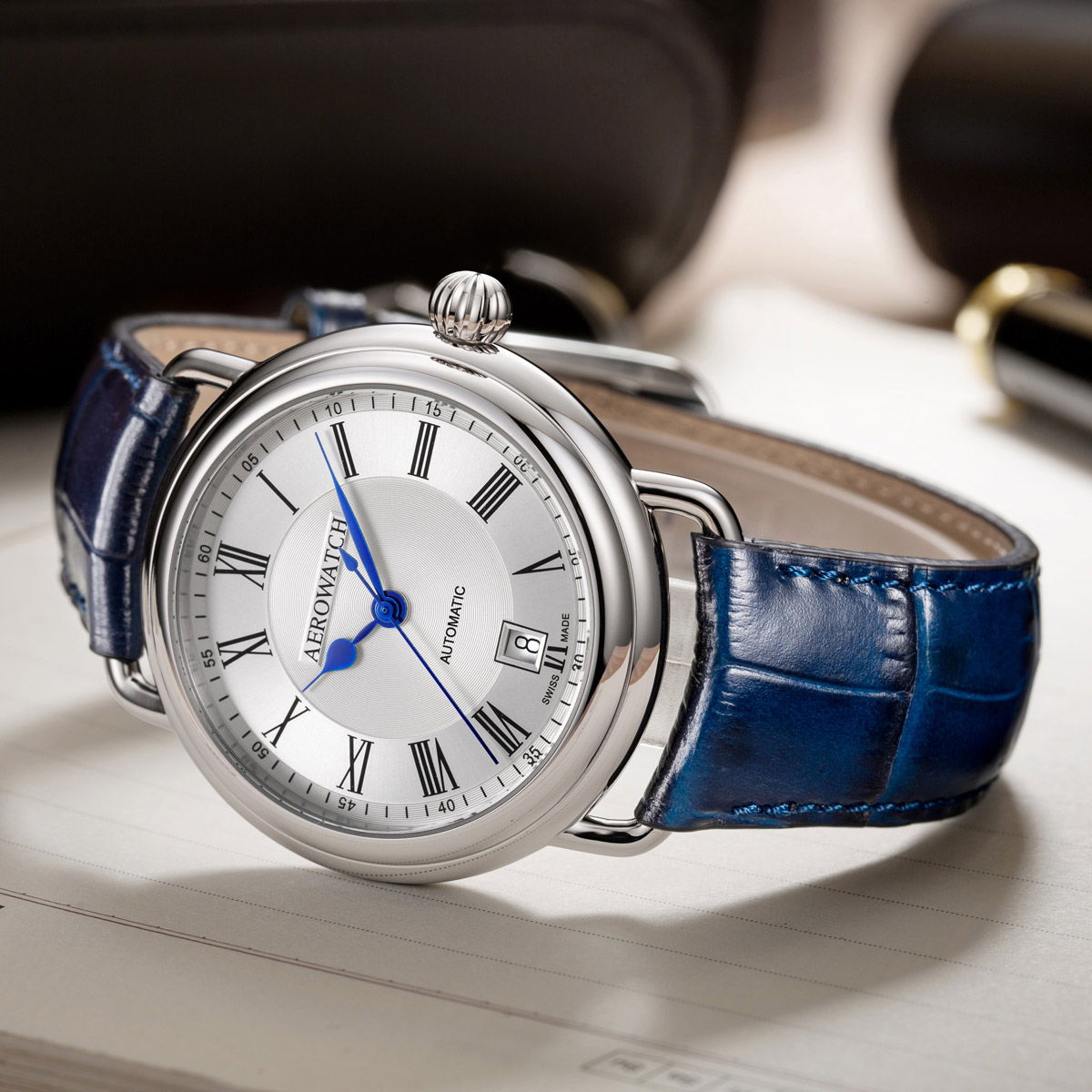 Elegant Aerowatch 1942 Automatic with a blue leather strap and silver dial, perfect for any occasion.
