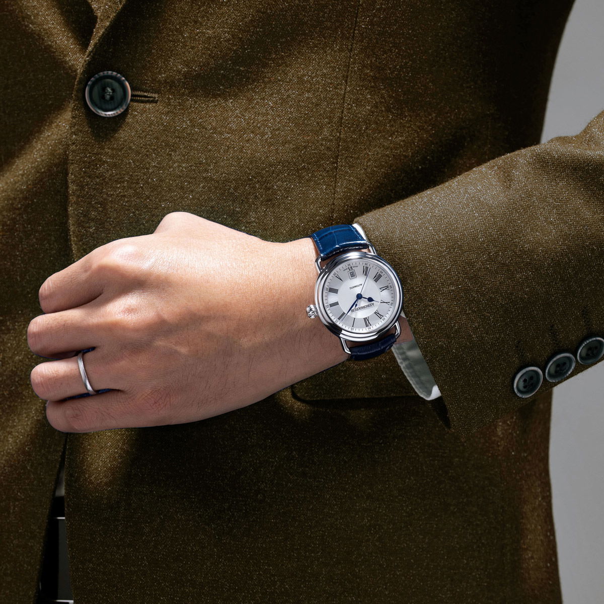Elegant Aerowatch 1942 Automatic on a wrist, complementing a stylish outfit with a blue leather strap.