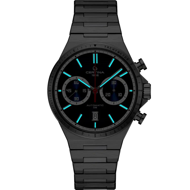 Certina DS-7 Chrono Auto C043.427.11.041.00 watch in a dark setting, highlighting its Super-LumiNova-coated hands and hour markers glowing in a vibrant blue hue. The luminescent details ensure excellent readability in low-light conditions, while the stainless steel case and bracelet maintain a sleek, modern aesthetic. The chronograph subdials and tachymeter bezel remain subtly visible, emphasizing the watch’s precision and functionality.