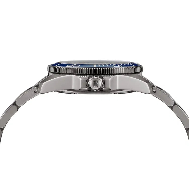 Side profile of the Certina DS Action Diver 40.5mm watch showing the brushed titanium case and bracelet, screw-down crown engraved with “DS,” and the blue ceramic bezel with white markings. The watch’s case thickness and curved lugs are clearly visible.