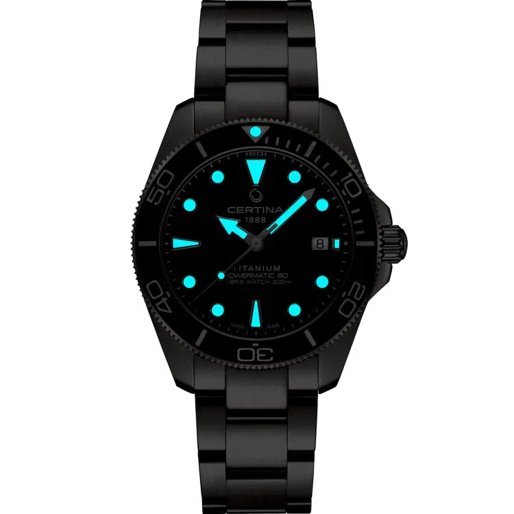 Night view of the Certina DS Action Diver 40.5mm watch with glowing blue Super-LumiNova® markers and hands on a dark blue dial. The inscriptions “CERTINA 1888,” “TITANIUM,” “POWERMATIC 80,” and “DIVER’S WATCH 300m” are visible, along with a luminous marker at 12 o'clock on the bezel and a date window at 3 o'clock.