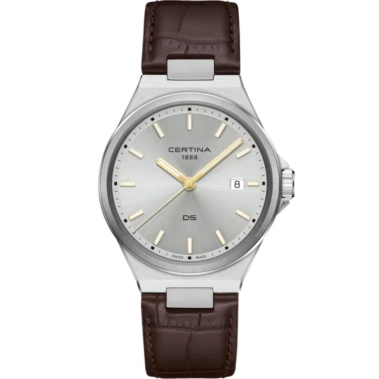 The Certina DS-7 Quartz watch (C043.410.16.031.00) displayed from the front, showcasing its silver sunburst dial with gold-tone hour markers and hands. A date window is positioned at 3 o’clock for added functionality. The stainless steel case has a polished finish, complementing the refined design. The brown leather strap features a crocodile-embossed texture with visible stitching, adding a touch of elegance. The "Certina 1888" logo is displayed below the 12 o’clock position, while the "DS" marking sits ab