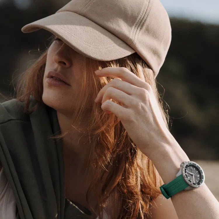 woman wearing certina ds-x gmt c047.452.17.081.00, swiss made watch with green rubber strap and stainless steel case in outdoor setting